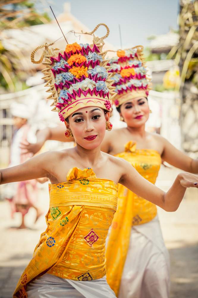 Balinese Hindu girls dancing in traditional costume at a religious cultural ceremony during Kuningan on the Indonesian island of Bali