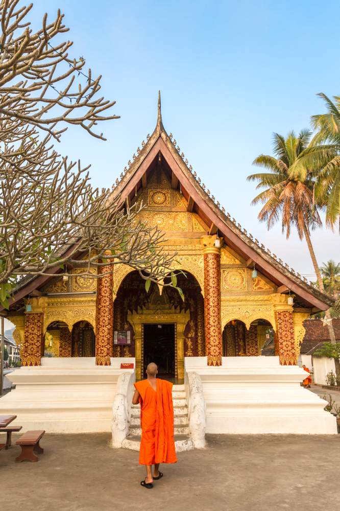 Buddhist monk walking into a temple in Luang Prabang, Laos